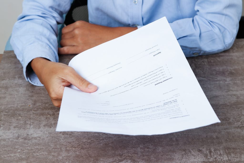 Closeup of business person giving document to viewer