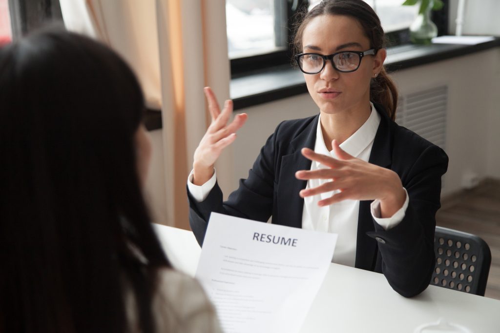 Confident millennial female applicant in glasses talking at job