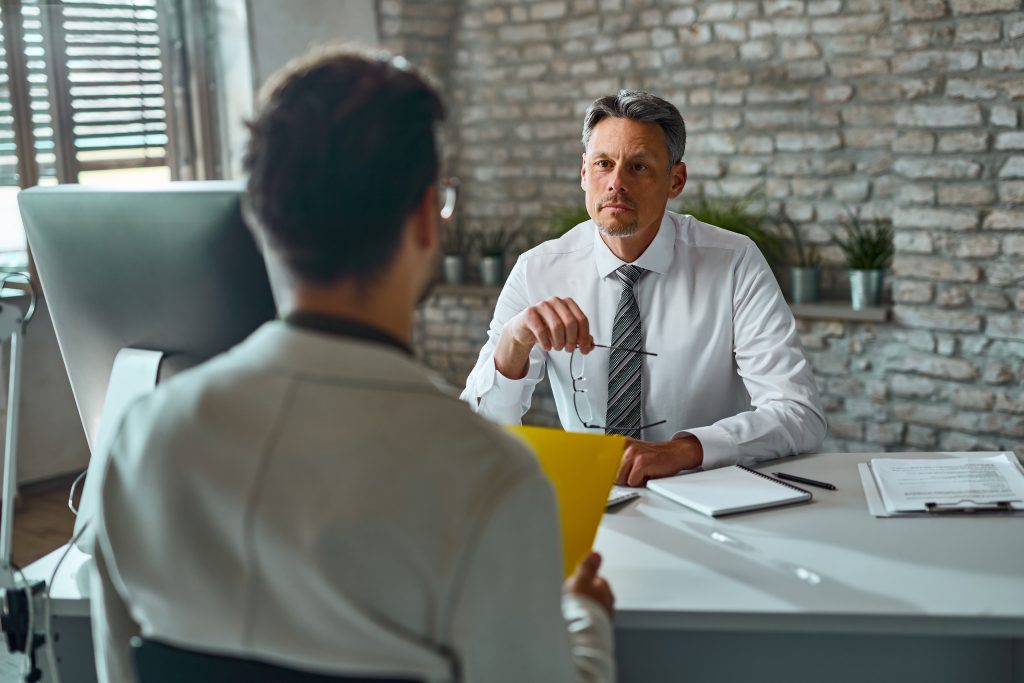 Businessman talking to a candidate during job interview in the o