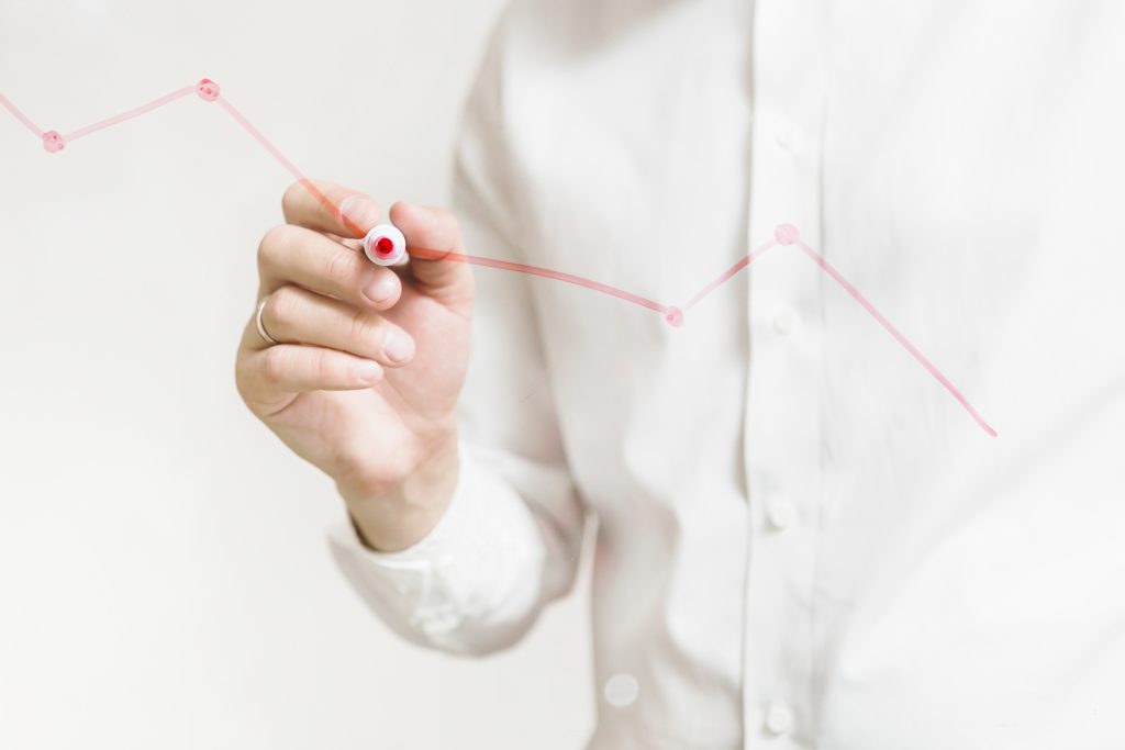 businessperson-s-hand-preparing-red-graph-glass-board track process in assessment