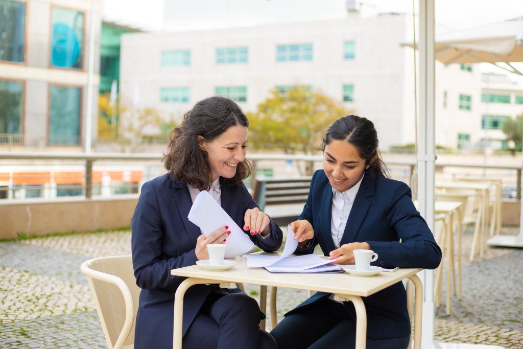 Businesswomen drinking coffee and working with papers state and central exam preparation